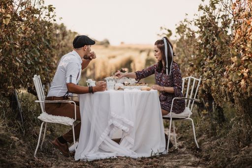A vertical shot of a happy couple enjoying breakfast outside