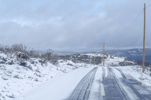 deserted snow covered mountain road with vehicle tyre marks, winter transport concept background