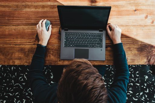 A top view of a male working on his laptop in the office