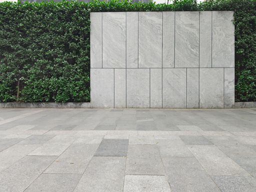 A building's yard with a green wall and concrete floor
