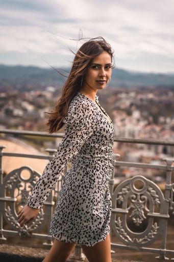 A vertical shot of a young beautiful woman standing near the fence in Spain