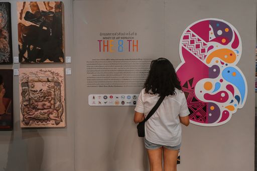 A woman standing in the Art Bridge Gallery in Chiang Rai, Thailand and admiring the art