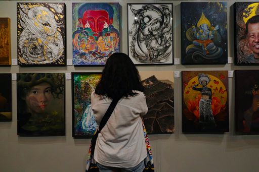 A back view of a female looking at artworks
