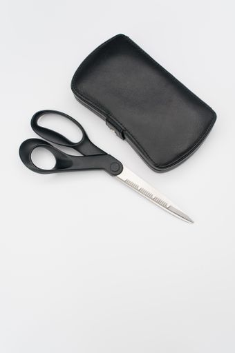 Black leather manicure set bag and scissors with copy space on white background