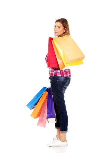 A vertical of a young Polish woman posing with her shopping bags isolated on the white background