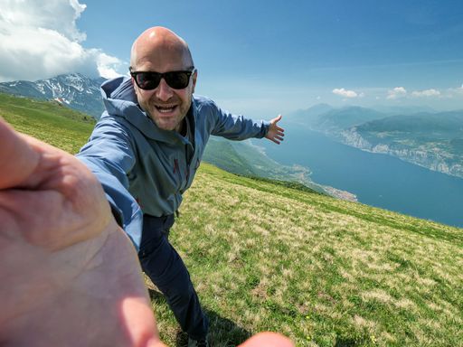 Happy Man Hike on top of the Monte Baldo with the Lake Garda at the background