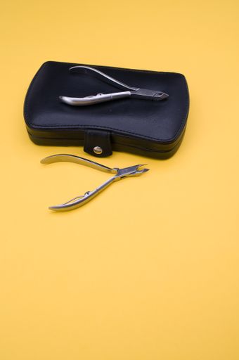 closed manicure set bag and nippers with copy space at the bottom on orange background