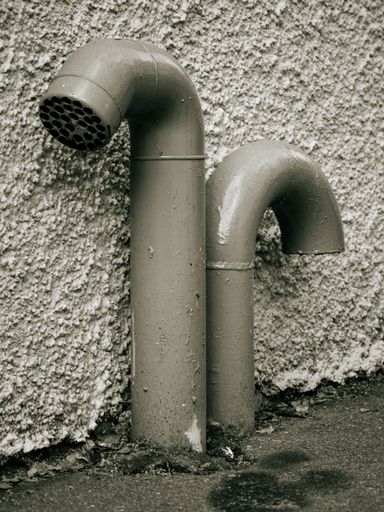 A closeup shot of drain pipes in the streets of Majorna, Gothenburg, Sweden. The image is in toned monochrome.