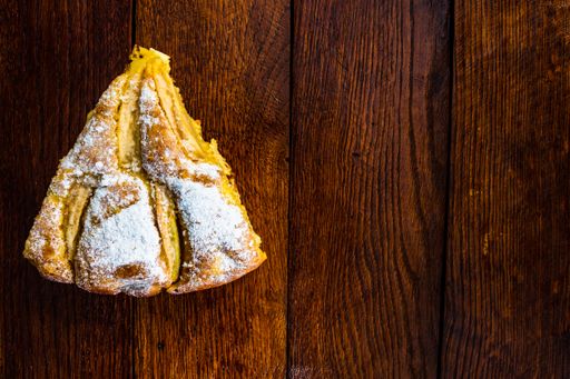 A top view of a sliced apple pie with cinnamon on a rustic wooden table