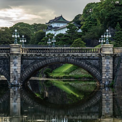 A closeup of Nijubashi Bridge with Tokyo Imperial Palace surrounded by trees on the background, Japan