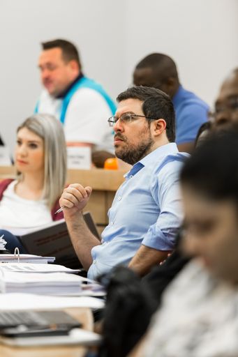 A vertical shot of diverse adult delegates attending a business lecture in a classroom in Johannesburg, South Africa