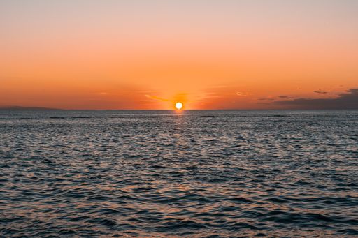 A gorgeous view of a golden sun hovering above the horizon in Rovinj, Croatia during a bright sunset