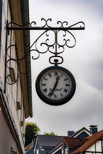 The vintage old clock hanging in the old town street