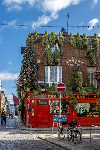 Dublin, Ireland, a shot of a red temple bar in the corner of the street with a Christmas tree
