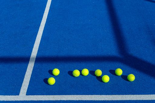 The eight balls on a paddle tennis court seen from close range
