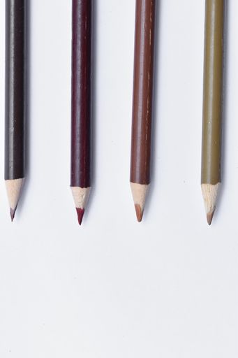 A vertical shot of parallel multicolor colored pencils isolated on a white backgrou