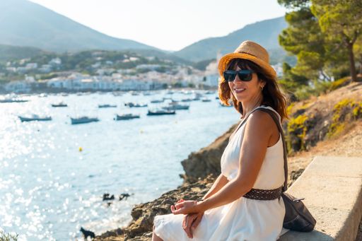 A young woman in a white dress in Cadaques by the sea in Costa Brava of Catalonia, Gerona
