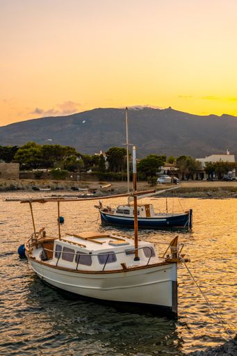 The sunset over the harbor captured from the beach of Platja De S'arenella in Cadaques, Spain