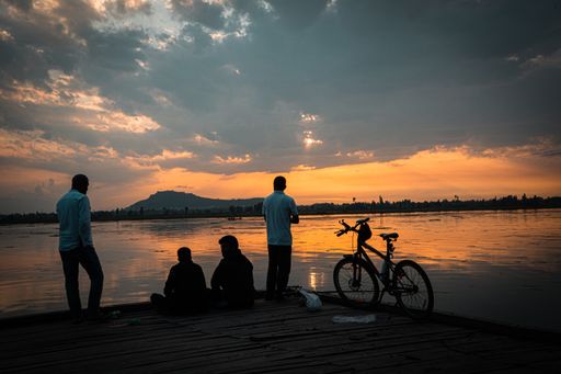 A view of people with a bicycle watching the beautiful sunset in Dal Lake, Srinagar, J&k, India