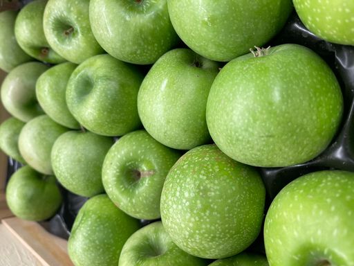 A stack of fresh ripe green apples at a market