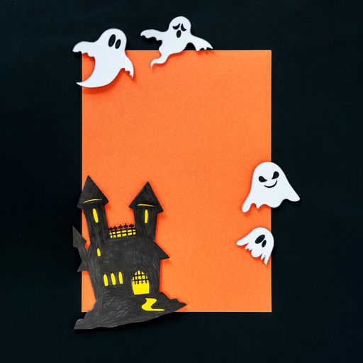 A closeup shot of an orange Halloween background with different 3d rendered Halloween decorations