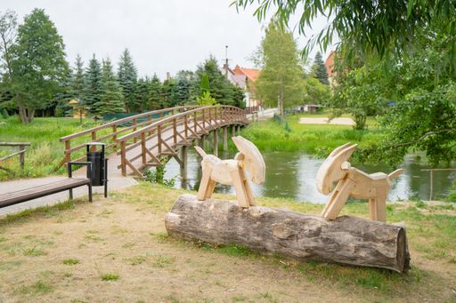 A closeup shot of wooden sculptures of two billy goats in a park in Swornegacie, Kashubia, Poland