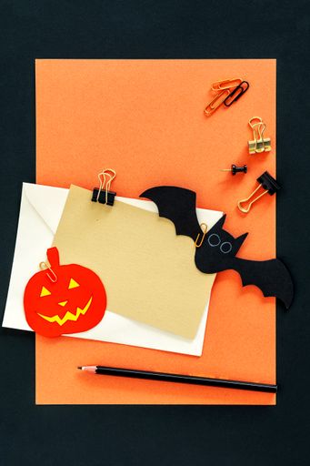 A closeup shot of an orange Halloween background with different 3d rendered Halloween decorations