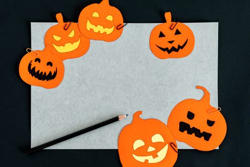 A closeup shot of a white background with 3d rendered Halloween decorations