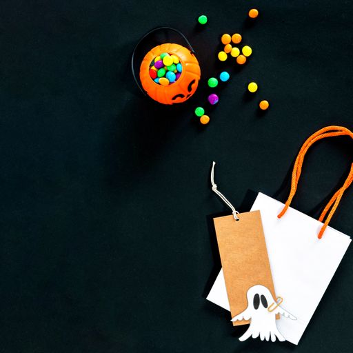 A black Halloween background with candy and copy space