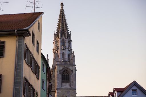 The tower of Konstanz Minster or Konstanz Cathedral near colorful buildings in Germany