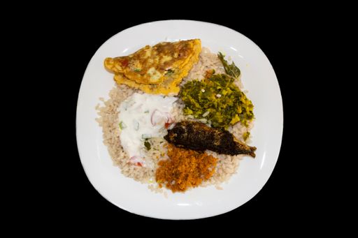 Kerala Style Lunch With Matta Rice Or Kuthari Choru, Omelette, Fish Fry, Chutney And Vegetable. Isolated Black Background