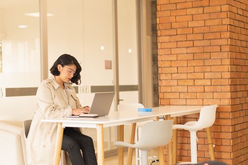 The beautiful young, short-haired woman working on the laptop.