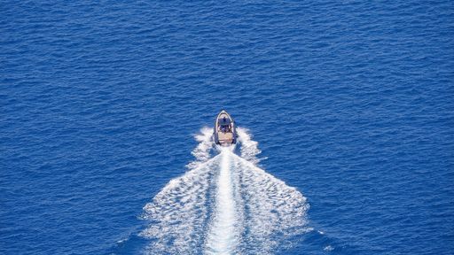 A boat in the green clear sea during the daytime
