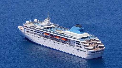 An aerial shot of the ETS tour cruise ship near the coast of Fira, Santorini island, Greece