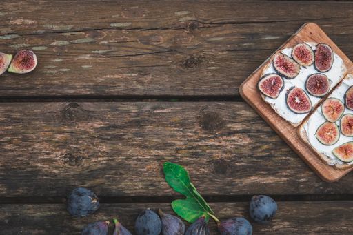 The Cream cheese sandwich with figs served on wooden board with copy space