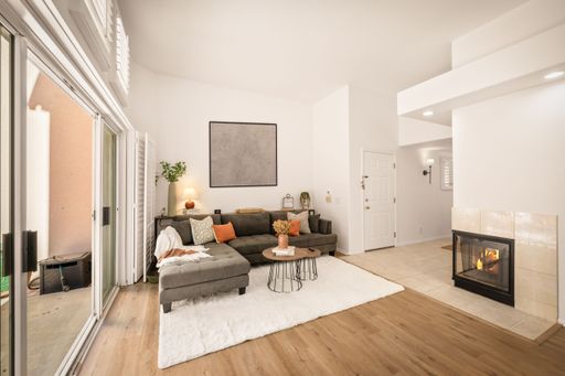 A serene home setting with neutral tones, large windows, modern decor, soft lighting, and cozy furnishings