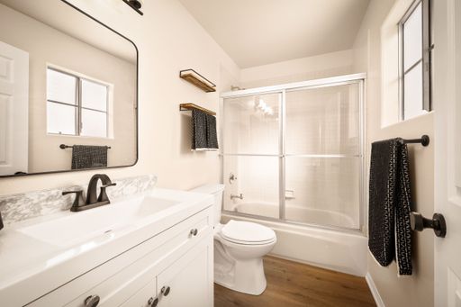 A bathroom scene with neutral tones, modern decor, soft lighting, and nice furnishings