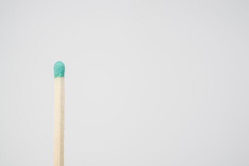 A closeup shot of a green match isolated on a white background