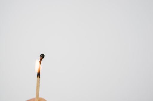 A closeup shot of a burning match isolated on a white background