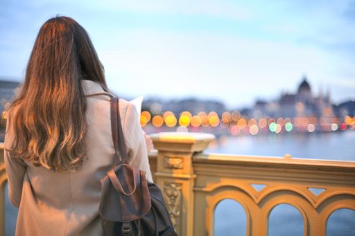 A Beautiful Shot Of Woman Wearing Trench Coat And Black Leather Backpack Standing At The Bridge