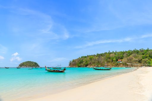 Kata Beach with crystal clear water and wooden traditional boat, famous tourist destination and resort area, Phuket, Thailand