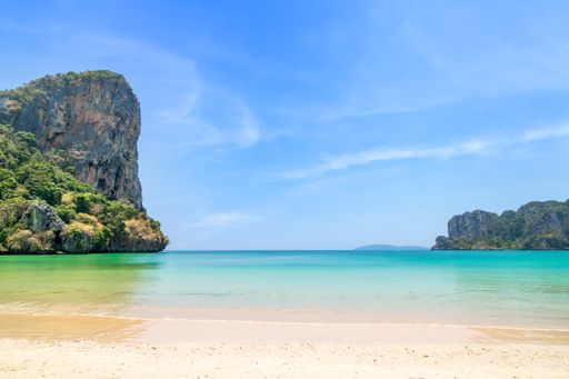 Railay beach west with crystal clear water and exotic landmark limestone cliff mountain, Krabi, Thailand