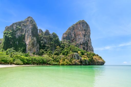 Railay beach west with crystal clear water and exotic landmark limestone cliff mountain, Krabi, Thailand