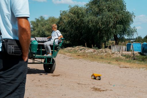 The beautiful shot of a boy in a carriage pulling his toy truck by a string