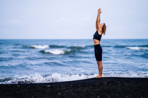 The woman practicing yoga on the background of the sea.