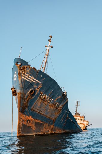 A vertical shot of a Shipwreck in the Sulina Branch of The Danube Delta against a cloudless sky