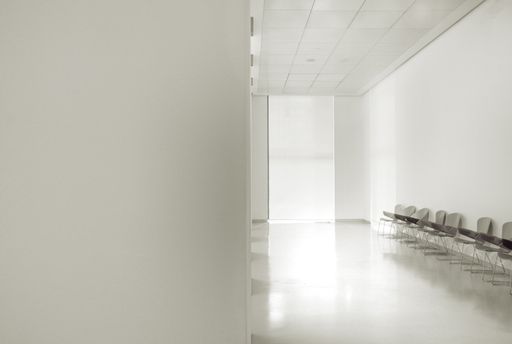 A white minimalistic corridor interier with chairs