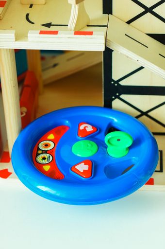 A closeup shot of a plastic blue wheel toy for children
