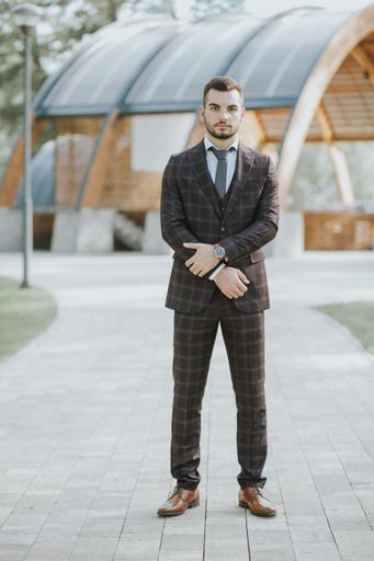 A handsome elegantly dressed Caucasian man posing outdoors