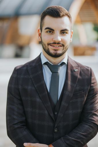 A handsome elegantly dressed Caucasian man standing outdoors